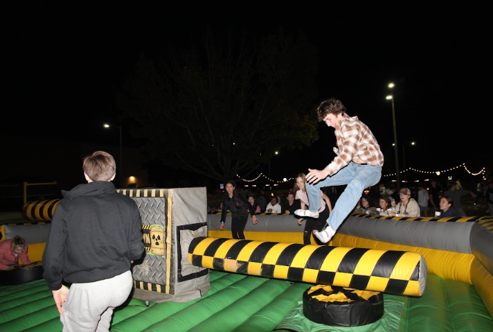 James Coleman takes flight over the spinning arm on the Meltdown inflatable game. This was the major attraction at Fall Fest, and there was always a crowd around the game awaiting their turn.